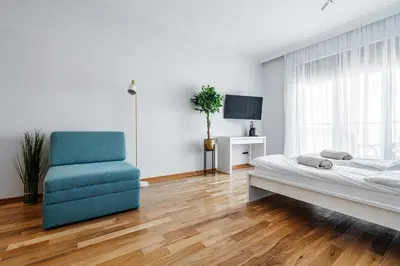 a bedroom with a bed and a blue chair at Przno Apartments by In Property in Pržno