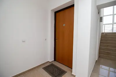a hallway with a wooden door and stairs at APARTMENTS ANI in Ulcinj