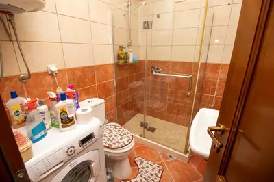 a bathroom with a shower and a washing machine at APARTMENTS ANI in Ulcinj
