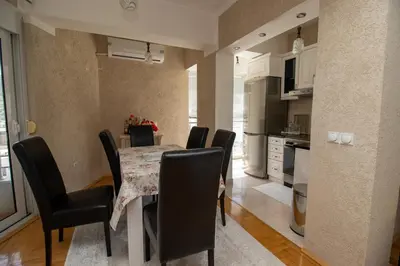 a kitchen and dining room with a table and chairs at APARTMENTS ANI in Ulcinj