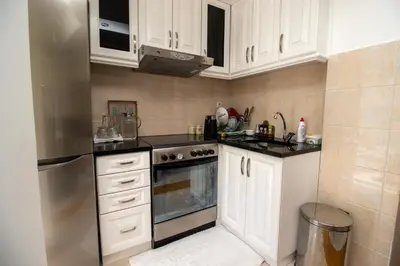 a kitchen with white cabinets and a stove top oven at APARTMENTS ANI in Ulcinj