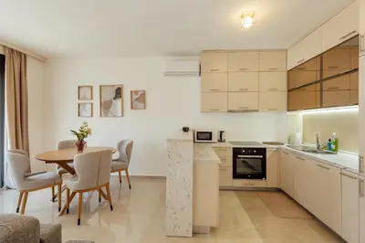 a kitchen and dining room with a table and chairs at Apartment Throne in Kotor