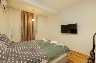 a bedroom with a bed and a flat screen tv at Apartment Throne in Kotor