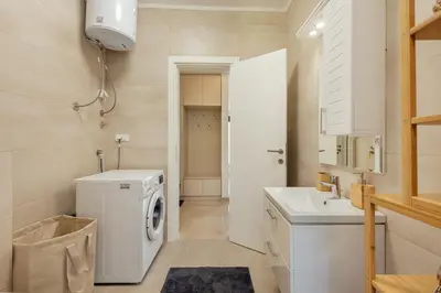 a white laundry room with a washer and dryer at Apartment Throne in Kotor