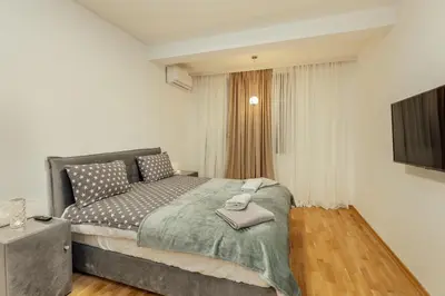 a bedroom with a large bed and a television at Apartment Throne in Kotor