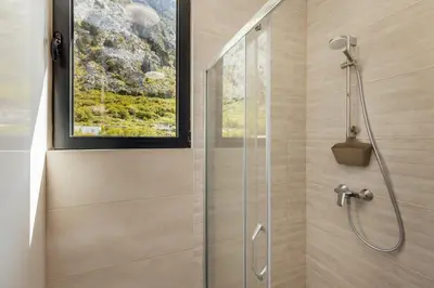 a shower with a glass door in a bathroom at Apartment Throne in Kotor