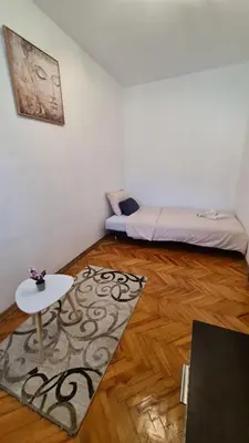 a room with a bed and a table and a rug at Boka apartment in Kotor