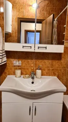a bathroom with a white sink and a mirror at Boka apartment in Kotor