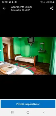 a green room with a bed and a tv at Apartmen Donji Stoj in Donji Štoj