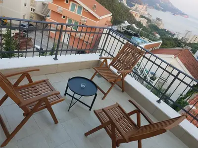 a balcony with two chairs and a table at Bulat 1 in Budva