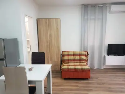 a living room with a chair and a table at Bulat 1 in Budva