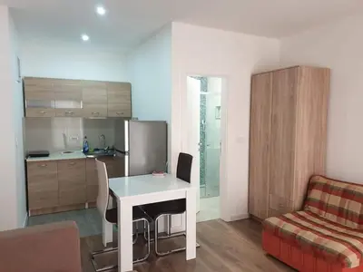a living room with a table and a kitchen at Bulat 1 in Budva