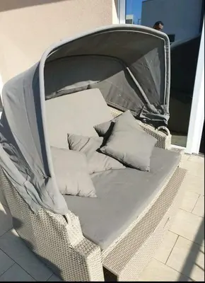 a wicker chair with pillows sitting on a patio at Bulat 1 in Budva