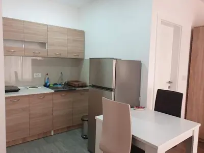 a kitchen with a white table and a refrigerator at Bulat 1 in Budva