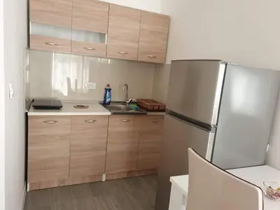 a kitchen with wooden cabinets and a stainless steel refrigerator at Bulat 1 in Budva