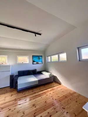 a bedroom with a bed and a wooden floor at Tina in Cetinje