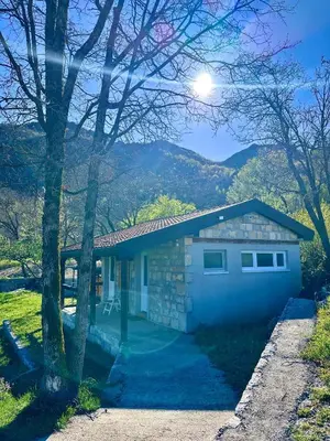 a house with a garage with mountains in the background at Tina in Cetinje