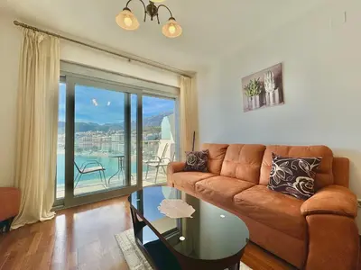 a living room with a couch and a glass table at Ponta Nova One bedroom Apartment with Sea view in Budva