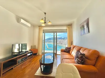 a living room with a couch and a television at Ponta Nova One bedroom Apartment with Sea view in Budva