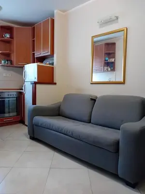a living room with a blue couch in a kitchen at Luna Apartman in Kotor