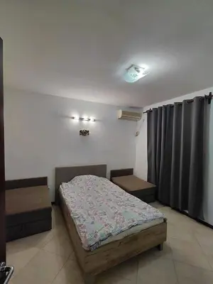 a bedroom with a bed and two tables in it at Luna Apartman in Kotor