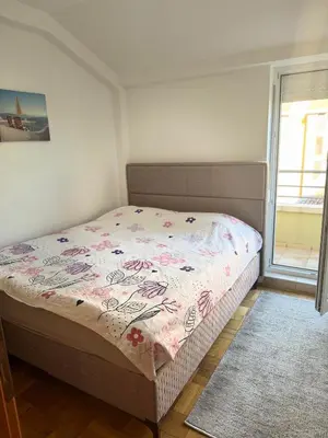 a bedroom with a bed with a floral bedspread at MBD apartment Budva in Budva