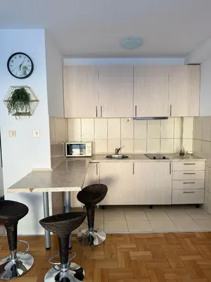 a kitchen with a counter and two bar stools at MBD apartment Budva in Budva