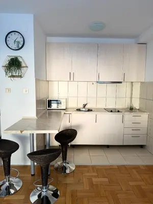 a kitchen with a table and two bar stools at MBD apartment Budva in Budva