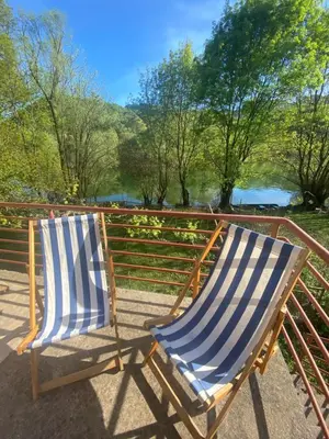 two blue and white chairs sitting on a railing at Rijeka crnojevica in Cetinje