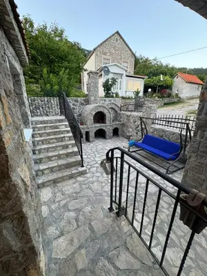 a patio with a bench and stairs with a house at Villagio in Virpazar