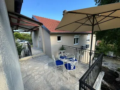 a patio with a table and chairs and an umbrella at Villagio in Virpazar