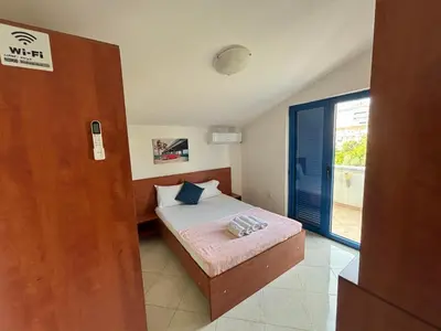 a small bedroom with a bed and a window at Glory Suites in Budva