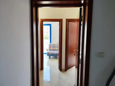 a hallway with two doors leading to a living room at Glory Suites in Budva