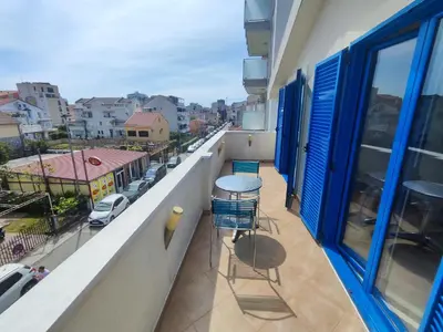 a balcony with a table and chairs and a view of a city at Glory Suites in Budva