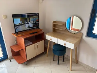 a dressing table with a mirror and a television at Glory Suites in Budva