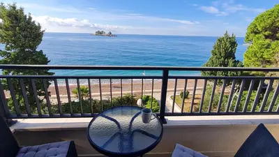 a table on a balcony with a view of the ocean at La Vista Apartment in Petrovac na Moru