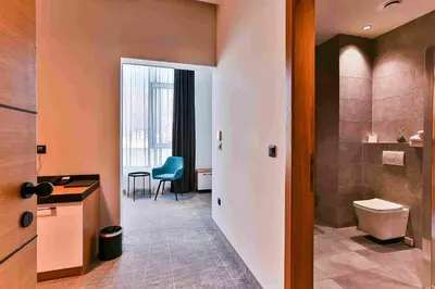 a bathroom with a toilet and a table and a chair at Hotel Boka in Kotor