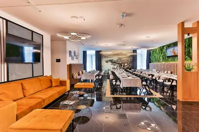 a restaurant with a couch and tables and chairs at Hotel Boka in Kotor