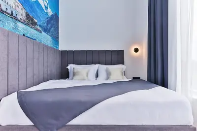 a bedroom with a large bed with white sheets and pillows at Hotel Boka in Kotor