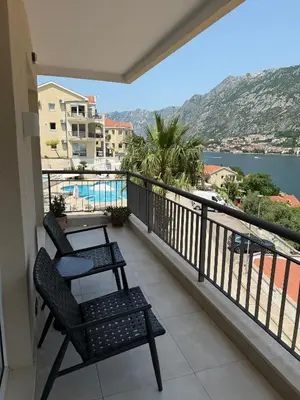 a balcony with two chairs and a view of the water at Vista Premium Apartment in Kotor