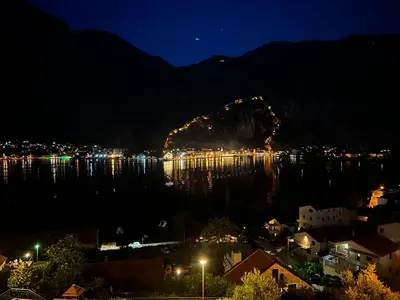 a night view of a city and a body of water at Vista Premium Apartment in Kotor