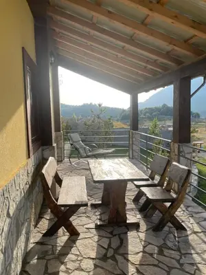 a table and chairs on a patio with a view at Holiday House Korita in Podgorica
