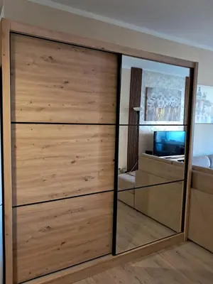 a bedroom with a large wooden closet with a mirror at Holiday Home Apartment in Budva