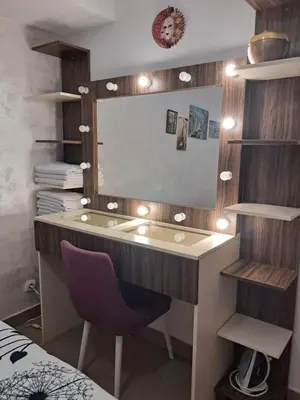 a bathroom with a vanity with a mirror and a purple chair at Holiday Home Apartment in Budva