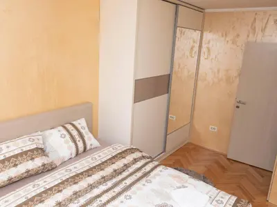 a bedroom with a bed and a glass door at Apartment Kosta in Podgorica