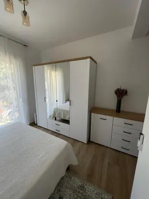 a bedroom with a bed and a large mirror at Listik Apartments in Becici