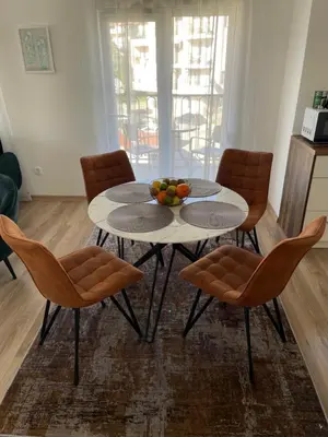a table with chairs and a bowl of fruit on it at Listik Apartments in Becici
