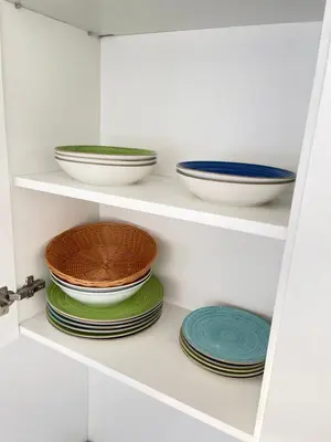 a white cabinet with plates and bowls on them at Listik Apartments in Becici