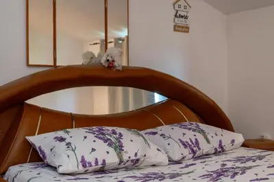 two stuffed animals sitting on the headboard of a bed at Vila Apartmani Astoria in Podgorica