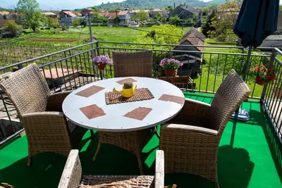 a table and chairs on a balcony with a view at Vila Apartmani Astoria in Podgorica